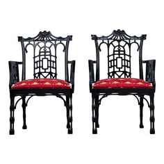 a pair of black chairs with red cushions