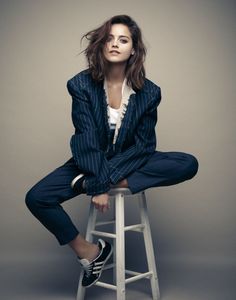 a woman sitting on top of a stool