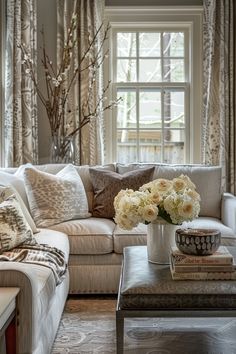 a living room filled with lots of furniture and flowers on top of a coffee table