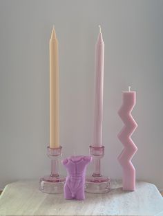 three candles are sitting on a table next to each other