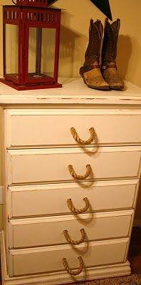 a pair of boots sitting on top of a white dresser next to a red lantern