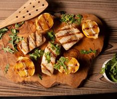 grilled fish and oranges on a wooden cutting board