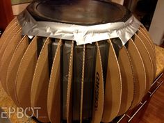 a drum is wrapped in brown paper and sitting on a counter top with other items around it