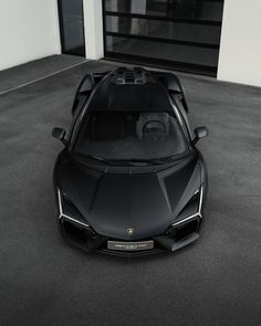 a black sports car parked in front of a garage