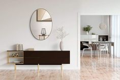 a living room with white walls and wooden flooring next to a dining room table