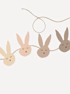 three bunnies with ears hanging from string