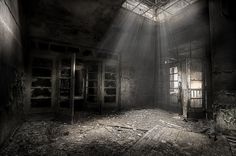 an abandoned building with sunlight streaming through the windows