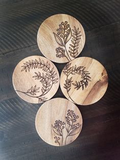 four wooden coasters with floral designs on them