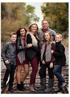 a family posing for a photo on train tracks