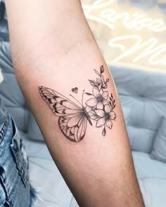 a black and white butterfly tattoo on the arm