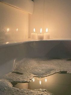 candles are lit in the middle of a bathtub