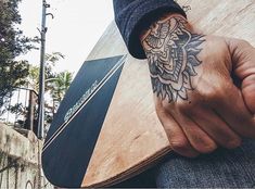 a man with a tattoo on his arm holding a surfboard