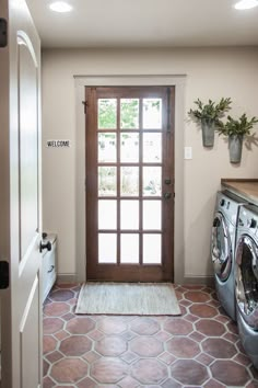 the front door is open and there is a washer and dryer in the room