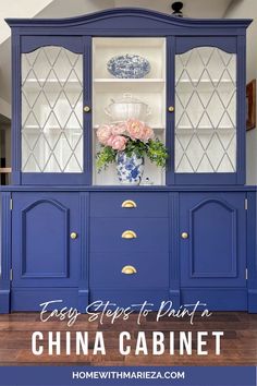 a blue china cabinet with flowers on top