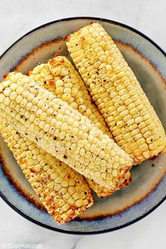 grilled corn on the cob in a blue plate