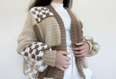 a woman wearing a brown and white knitted cardigan