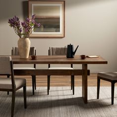 a wooden table with two chairs and a vase filled with flowers