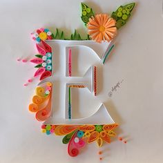 the letter e is made out of paper and decorated with flowers