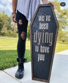 a woman standing next to a sign that says we've been dying to have you