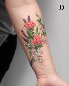 a woman's arm with flowers and leaves tattooed on the left side of her arm