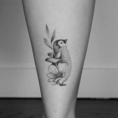 a black and white photo of a person's leg with a bird on it