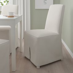 a white chair sitting next to a table with a cup and saucer on it