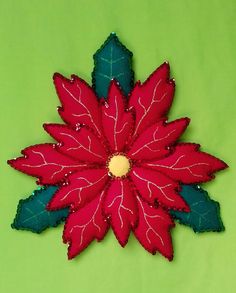 a red and green poinsettia sitting on top of a green tablecloth