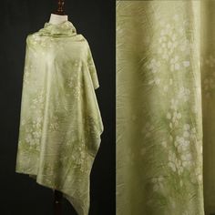 a green shawl with white flowers on it