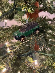 a green car ornament hanging from a christmas tree