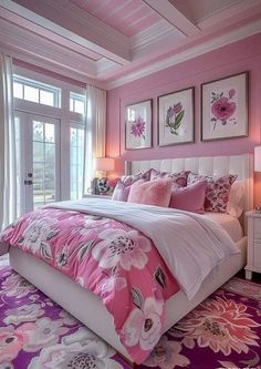 a bedroom decorated in pink and white with lots of flowers on the bed, along with framed pictures