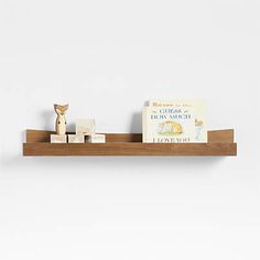 a wooden shelf with some books on top of it and a bear figurine next to it