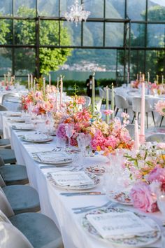 a long table set up with flowers and candles for a formal dinner or wedding reception