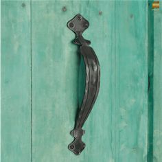 a metal handle on a green wooden door