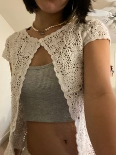 a close up of a person wearing a top with crocheted lace on it