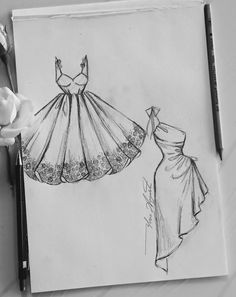 a drawing of a dress on paper next to a pen