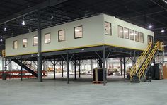 an empty warehouse with stairs leading up to the second floor and two stories above it