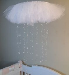 a baby crib with a chandelier hanging from it's ceiling in a nursery