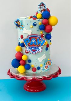 a birthday cake decorated with balloons and paw patrol characters