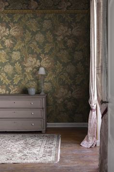 a bedroom with floral wallpaper and a dresser