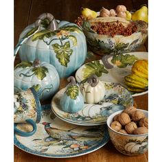 a table topped with plates and bowls filled with different types of dishes covered in painted pumpkins