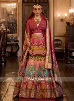 a woman in a red and gold bridal outfit