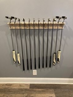 there are many golf clubs hanging on the wall