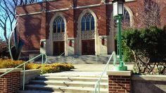 an old brick building with stairs leading up to the front door and steps down from it