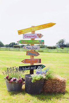 there are many signs on the pole in the yard that say different places to go