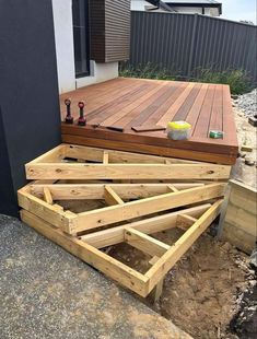 a wooden deck is being built with tools and wood planks on the bottom half