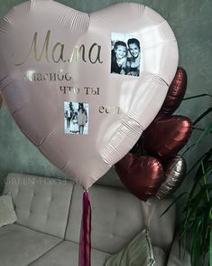 a pink heart shaped balloon with two photos attached to it and the words mama written on it