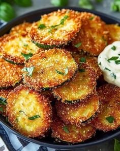 some fried food is in a black bowl on a blue and white checkered table cloth