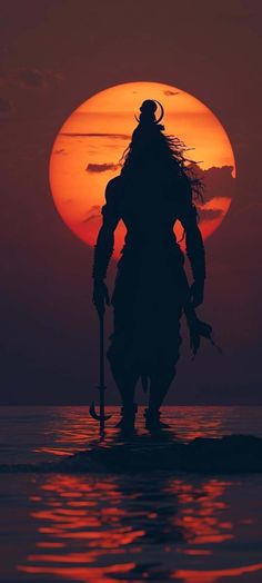 the silhouette of a person standing in the water with a paddle and wearing a horned headdress