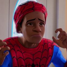 the spider - man is wearing a red and blue shirt with his hands up in front of him