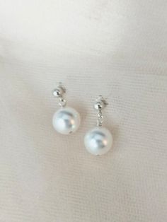 Classic white pearl drop earrings.   Luminous Swarovski pearls dangle on dainty sterling silver ball and post earring closures.  They come in a variety of colors too! The pearls are 10mm (approx. 3/8 inch) in diameter which are my largest sized pearl. Be pearl BOLD! Earrings Pearl Drop, Earrings Minimal, Earrings Pearl, Minimal Jewelry, Earrings White, Swarovski Pearls, Pearl Drop Earrings, Earrings Dangle, Pearl Drop